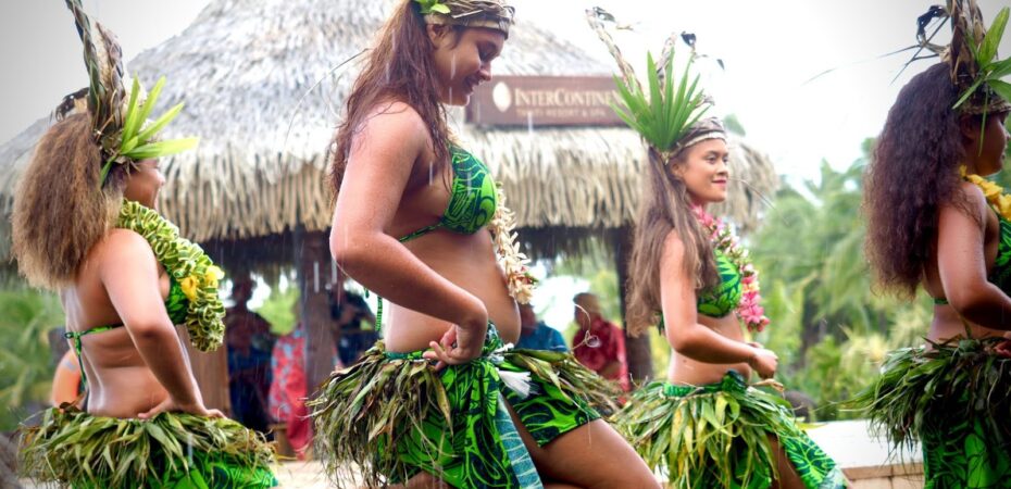 Tahitian women in costume doing a traditional dance.