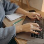 Free Person Typing on a Macbook  Stock Photo